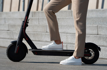 Obraz premium Close up photo of woman standing on electric scooter