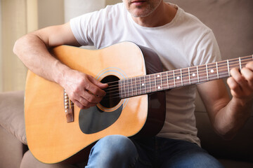 Fototapeta premium Detail of guitar body and man playing man playing