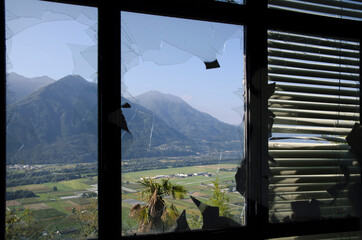 Panoramic View over Mountain from an Abandoned Building Seen Through a Broken Window.