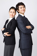 young businessman and businesswoman looking at camera back to back