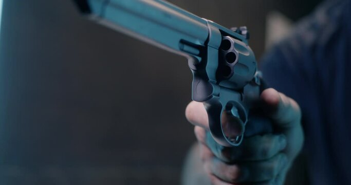 Unrecognizable man reloading revolver in shooting range