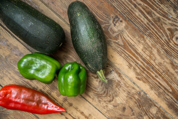 Freshly harvested vegetables. On a wooden background, top view of healthy vegetables, red and bell peppers, zucchini. Selective focus, shallow depth of field