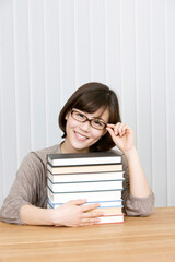 young woman with a pile of books