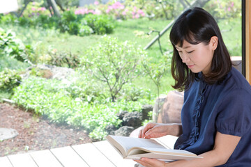 Obraz premium young woman reading a book by window