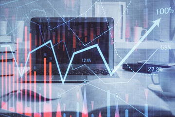 Stock market graph on background with desk and personal computer. Double exposure. Concept of financial analysis.