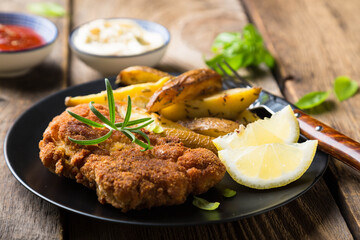 Homemade breaded German Weiner schnitzel with potatoes and lemon