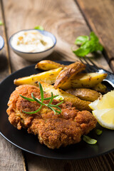 Homemade breaded German Weiner schnitzel with potatoes and lemon