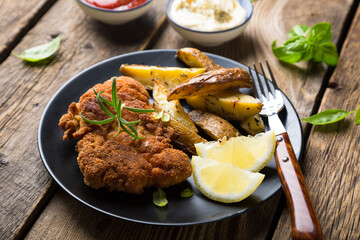 Homemade breaded German Weiner schnitzel with potatoes and lemon