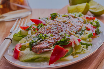 grilled mackerel with salad and garnish.