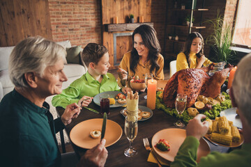 Portrait of nice attractive cheerful family parents grandparents sitting around served table eating homemade tasty delicious fresh dinner meal at modern loft brick industrial interior house