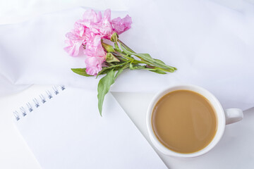 Obraz na płótnie Canvas Flat lay flowers romantic still life. Morning coffee mug for breakfast, empty notebook with copy space for text or challenge today and pink flowers. Freelancer woman workplace