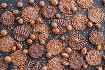 Milky and bitter round shape chocolate Madlen,designed on black background with ball chocolate and grains