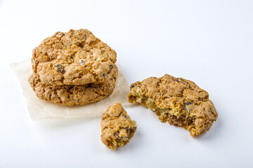 Homemade oatmeal cookies with raisins and chocolate on white background. Healthy snack before bedtime or nutritious breakfast. Fresh baked wholegrain cookies