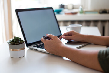 Woman working on her laptop with blank copy space screen. Mock up laptop with womans hands. Back view of business women hands busy using laptop. Home office. Quarantine. Coronavirus concept. Stay home