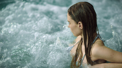 Closeup sexy girl enjoying jacuzzi spa. Macro of pretty woman relaxing in pool