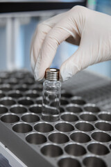 Close-up of hand loading a test tube with DNA samples for polymerase chain reaction. Image in blue tones