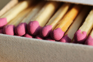 Matches with pink combustible heads in a box. Macro photography.