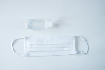 Coronavirus protection concept with medical mask, thermometer, hand sanitizer in the white background. Wuhan second wave lockdown. Covid-19 coronavirus pandemic. Copy space