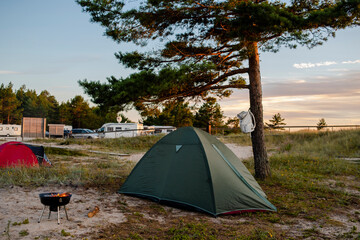 Tourist tent in camping on meadow near forest