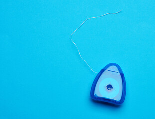 blue plastic packaging with dental floss on a blue background
