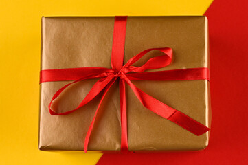 Gift box with red bow on bright background.