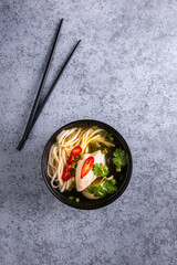 Fototapeta na wymiar Chicken asian soup on vertical gray background
