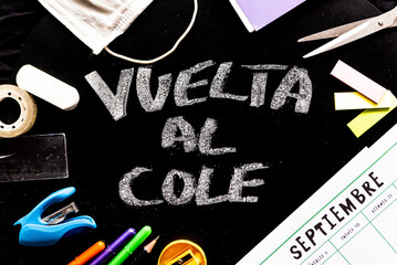 Vuelta al cole text in spanish, meaning back to school, with covid19 face mask on desk with calendar saying septiembre-september in spanish. education is an issue in the time of corona virus