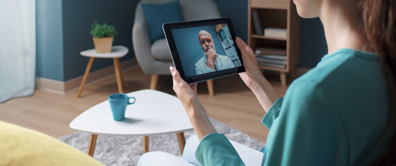 Woman having a video call with her doctor - obrazy, fototapety, plakaty