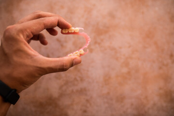 Hand holding a flexible denture