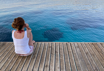 woman sitting wooden floor on the sea