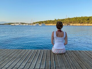 Fototapeta na wymiar woman sitting wooden floor on the sea
