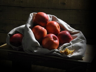 Red apples in a bag on a wooden background.