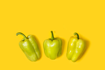 Pimientos verdes sobre un fondo amarillo liso y aislado. Vista superior. Copy space