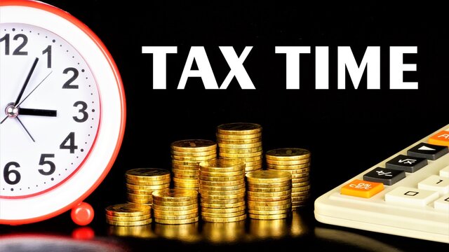 Tax time - text message on the background of money coins. Financial expenses for payment of necessary fees, duties and mandatory payments.