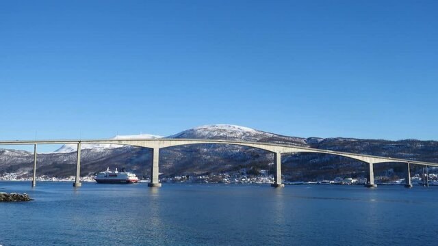 FINNSNES, TROMS, NORWAY, MARCH 11 2019:  cruise service vessel Hurtigruten under the Finnsnes bridge, Troms
