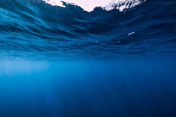 Underwater background with waves and sun rays. Transparent underwater sea