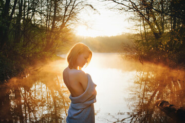 an attractive woman in nature enjoys the sunrise