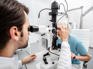 Experienced doctor checks the eyesight of an elderly woman. Modern clinic for checking and treating...