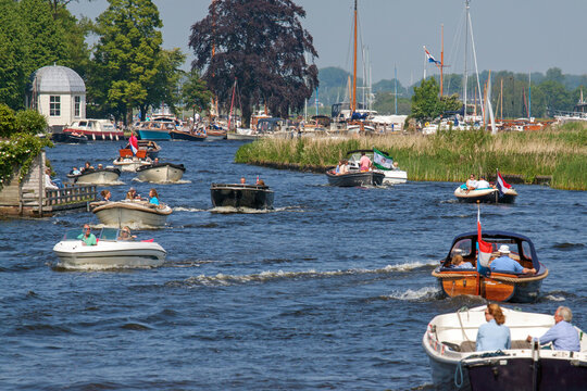 Busy Leede river near Warmond, Netherlands, with recreational boats on a sunny sunday in spring