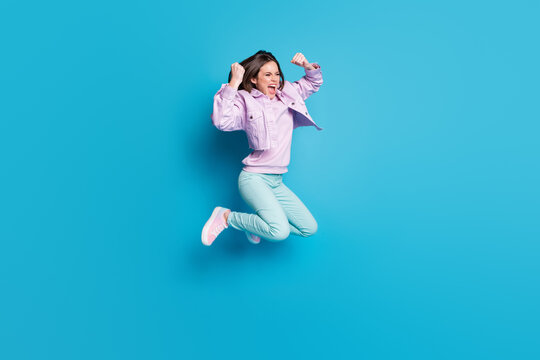Full length profile photo of crazy pretty lady jump up supporting sports team cheerleader competition wear casual denim violet jacket sweater pants shoes isolated blue color background