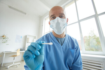Fototapeta premium Horizontal medium portrait of general practitioner wearing protective mask and gloves going to take swab test