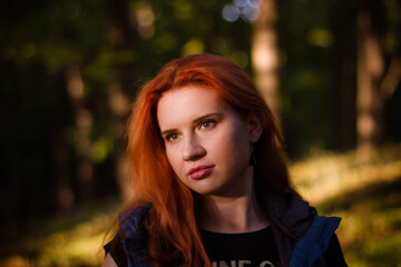 Naklejka premium portrait of a young red-haired girl in the park