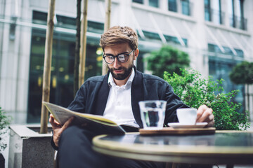 Relaxed man reading newspaper in cafe