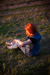portrait of a young red-haired girl in the park