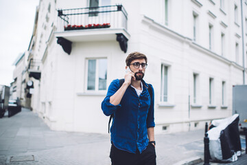 Serious man talking on smartphone on street