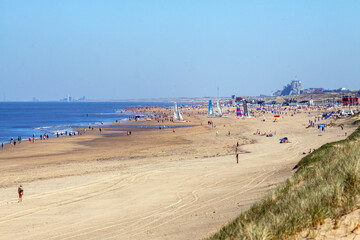 Noordwijk, Netherlands: sunny clear day at the beach; on the horizon buildings of Zandvoort - obrazy, fototapety, plakaty