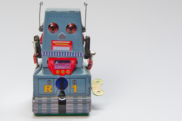 Fototapeta premium Aufziehbarer retro Spielzeug Roboter aus Blech vor neutralem Hintergrund