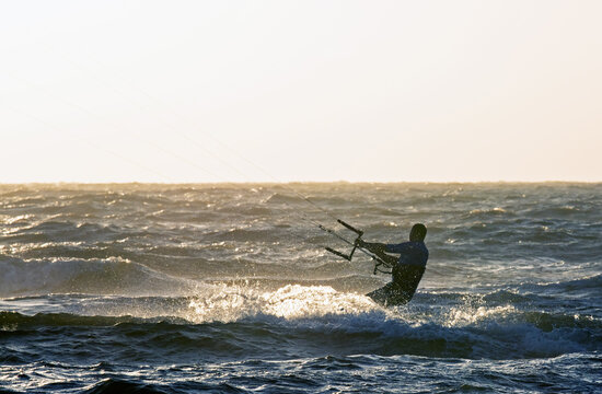 Kitesurfer in backlight at sunset; coast of Holland 