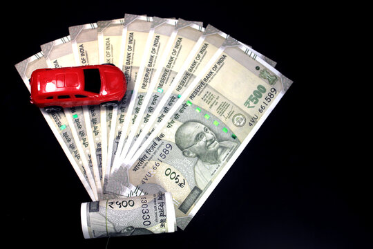 Indian currency. 500 rupee note with toy car. Indian currency isolated on black background. Buying car concept.