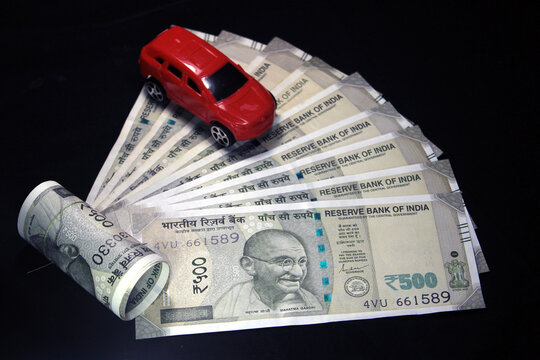 Indian currency. 500 rupee note with toy car. Indian currency isolated on black background. Buying car concept.